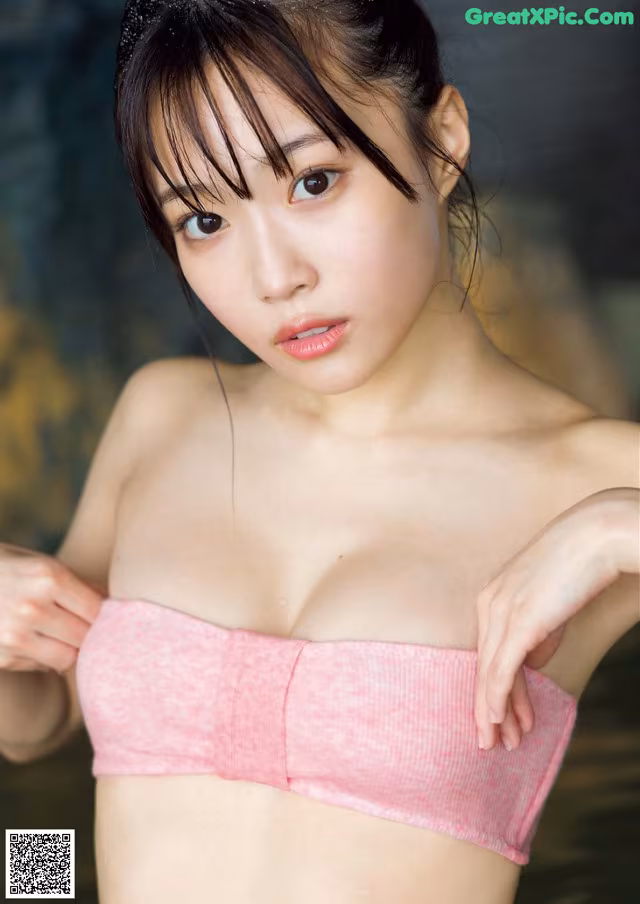 A woman in a pink bikini posing for a picture.
