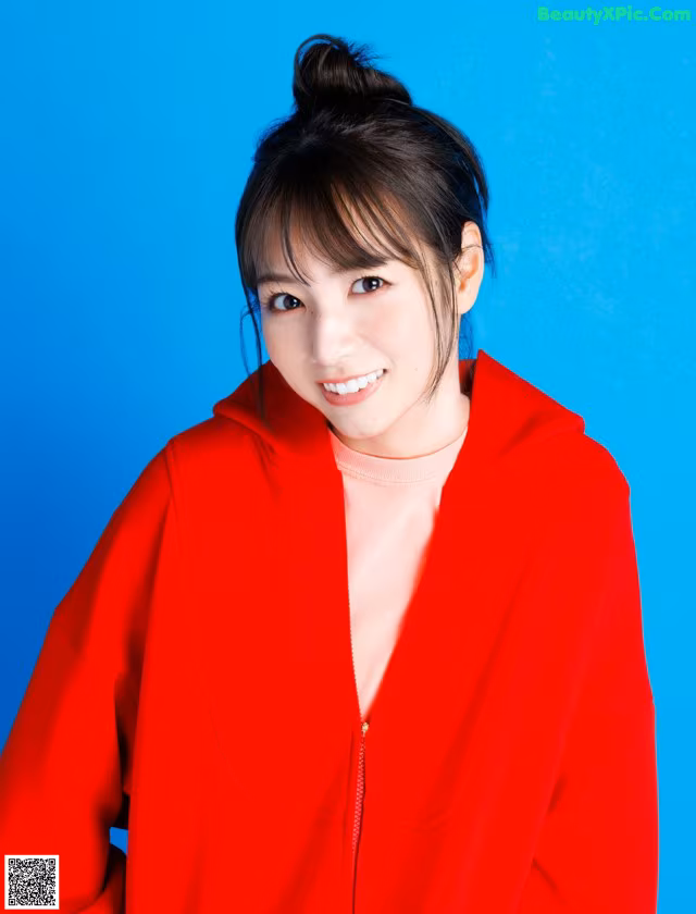 A woman in a red jacket posing for a picture.