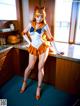 A woman in a sailor outfit posing in a kitchen.