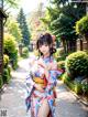 A woman in a kimono standing in the middle of a street.