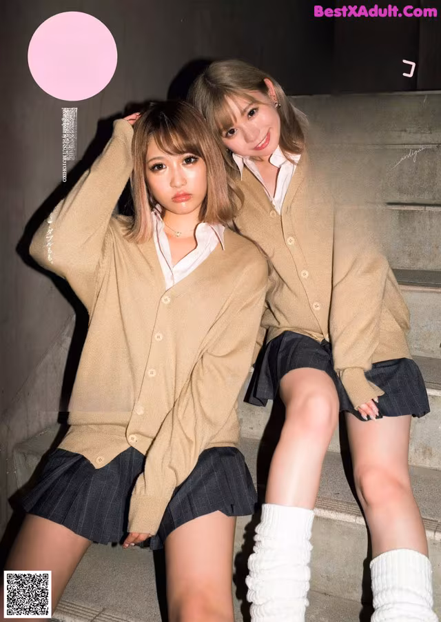 Two young women sitting on the steps of a building.