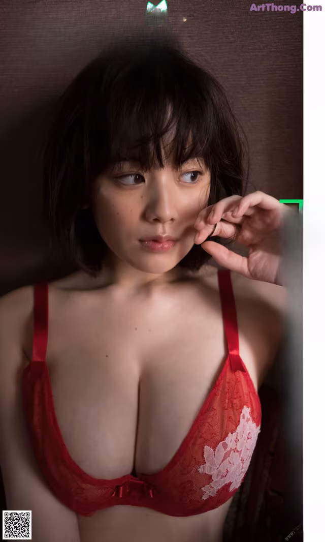 A woman in a red bra and panties posing for a magazine.