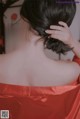 A woman in a red dress with her back to the camera.