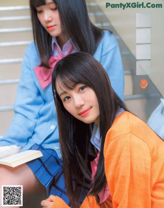 A couple of young women sitting next to each other.