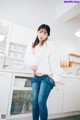 A woman standing in a kitchen with her hands on her hips.