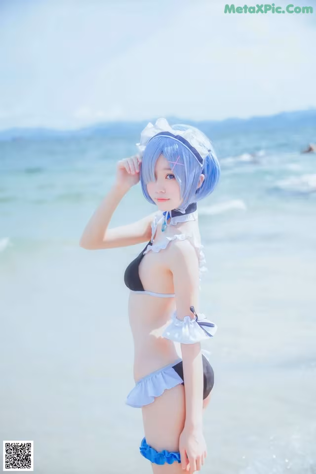A woman in a bikini standing on the beach.