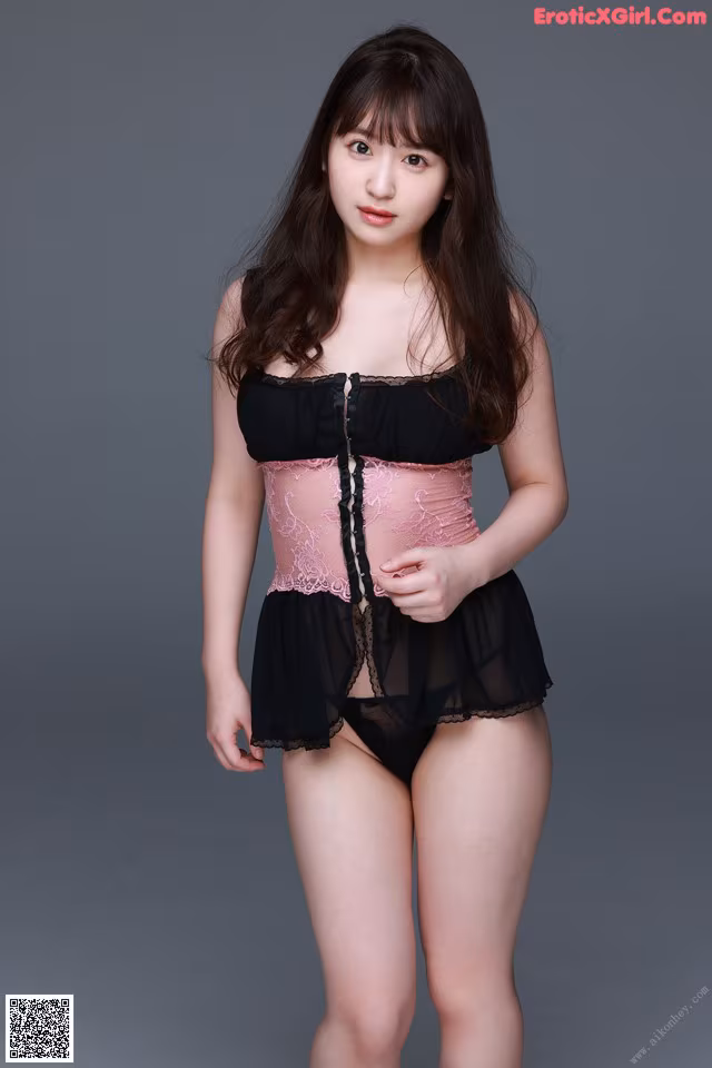 A woman in a pink and black corset posing for a picture.