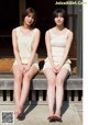 Two young women sitting on a wooden bench. 