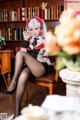 A woman sitting on a chair in front of a book shelf.