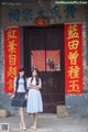 Two young women standing in front of a building.