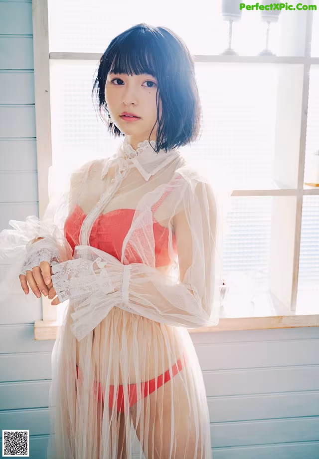 A woman in a red and white lingerie posing for a picture.